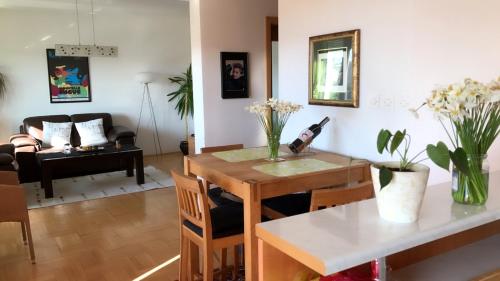 a living room with a table with flowers on it at Orion Apartment 1 in Prishtinë