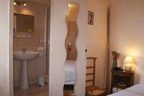 een badkamer met een wastafel en een douche in de kamer bij Hôtel le Dauphin in Moulins-la-Marche