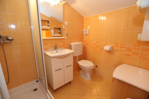 a bathroom with a toilet and a sink and a shower at Studio Neven with Sea View in Baška
