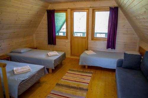 a room with two beds and a couch and windows at Holiday Home with Sauna in Kassari