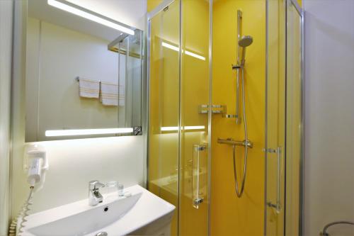 ザンクト・ヴォルフガングにあるHaus Seeschwalbeのバスルーム(洗面台、ガラス張りのシャワー付)