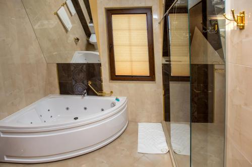 a bathroom with a tub and a glass shower at Hotel Green Garden in Shumen