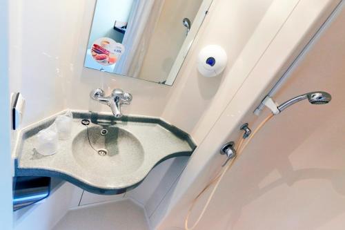 a bathroom with a sink and a mirror at Premiere Classe Dreux in Dreux