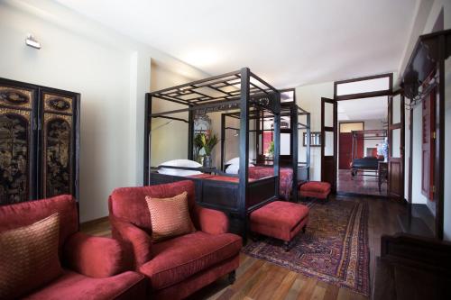 a bedroom with a bed and a couch and a chair at Seven Terraces in George Town