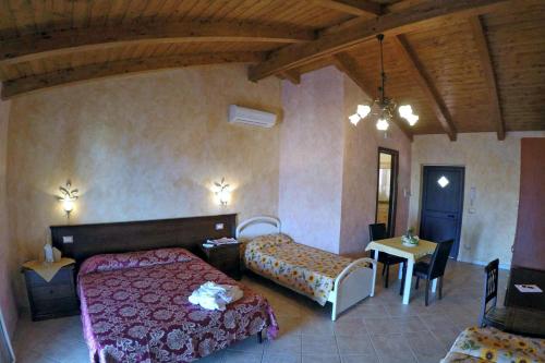 a bedroom with two beds and a table and chairs at Villa Paladino - B&B e Guest House in Scilla