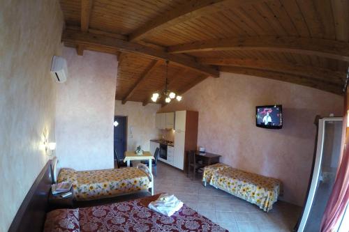 a hotel room with two beds and a television at Villa Paladino - B&B e Guest House in Scilla