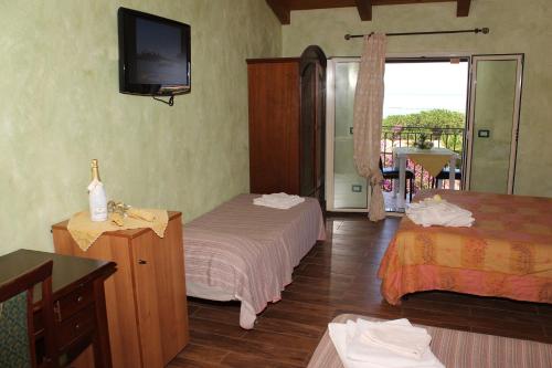 a hotel room with two beds and a television at Villa Paladino - B&B e Guest House in Scilla