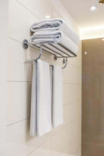 a group of towels hanging on a rack in a bathroom at Mava Apartamente in Constanţa