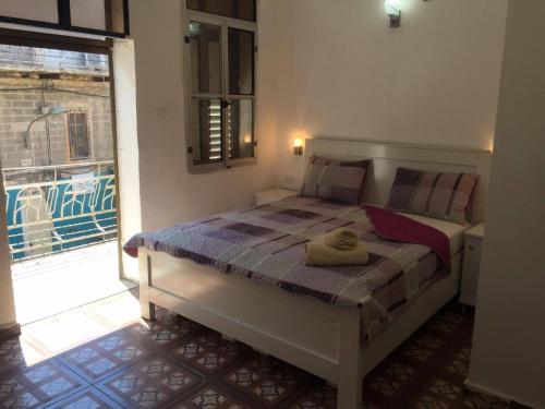 een slaapkamer met een bed en een groot raam bij Akko Gate Hostel in Akko