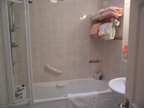 a bathroom with a tub and a sink at Croi an Bháile Luxury Apartment in Rosscarbery