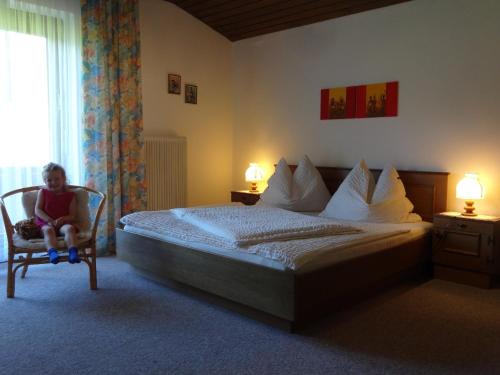 a person sitting in a chair in a bedroom at Haus Erlbacher in Abtenau