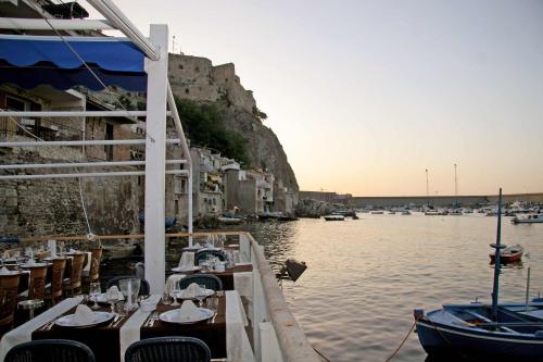 a dock with tables and chairs on the water with boats at Villa Paladino - B&B e Guest House in Scilla