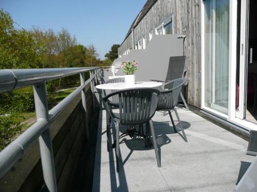 eine Terrasse mit Tisch und Stühlen auf einem Balkon in der Unterkunft Kaapshoff 32 in Hollum