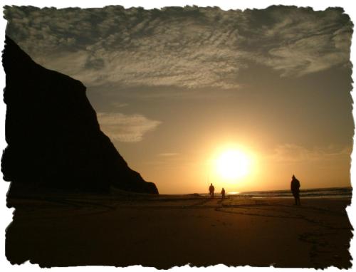 a group of people walking on the beach at sunset at Tonel Apartamentos Turisticos in Sagres