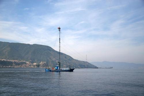 a boat in the water with a mountain in the background at Villa Paladino - B&B e Guest House in Scilla