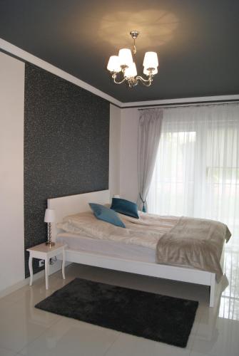 Schlafzimmer mit einem großen Bett und einem Fenster in der Unterkunft Apartament pod zamkiem in Olsztyn