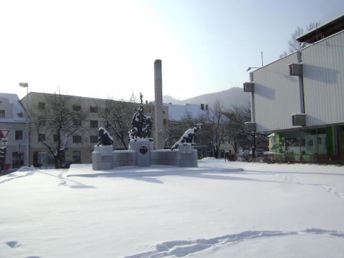a statue in the middle of a snow covered street at Guest House Veronika in Kočevje