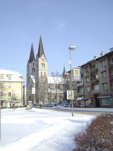 a church in a city with snow on the street at Guest House Veronika in Kočevje