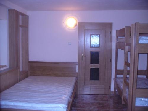 Zimmer mit 2 Etagenbetten und einer Tür in der Unterkunft Piteľová-Babica in Pitelová