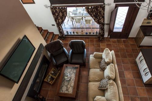 vista sul soffitto di un soggiorno con divano e sedie di Vivienda rural La Monería a Las Delgadas