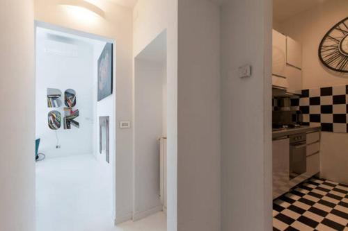 Pokój z kuchnią i zegarem na ścianie w obiekcie Apartment 3BR 2BT - Naviglio w Mediolanie