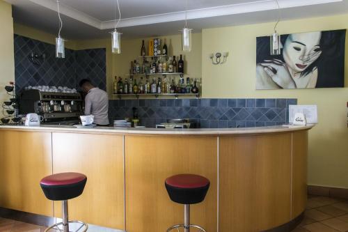 a man standing at a bar in a restaurant at Hotel Baia in Palinuro
