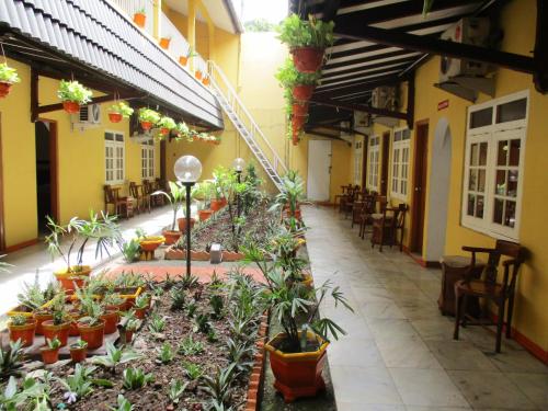 a courtyard of a building with potted plants and chairs at Hotel Tugu Asri in Jakarta