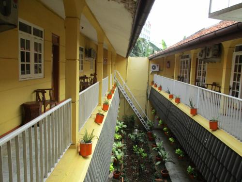 un balcone di un edificio con piante sopra di Hotel Tugu Asri a Giacarta