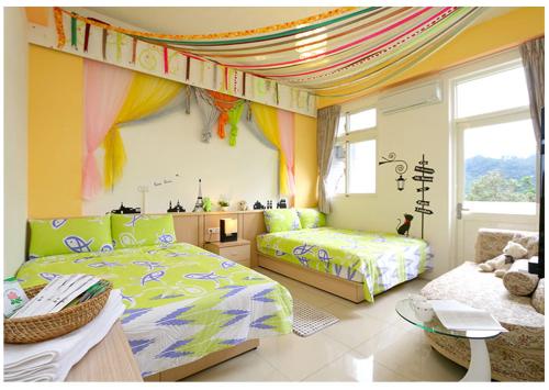 a childrens bedroom with two beds and a window at Hong Lai Guest House in Jiaoxi