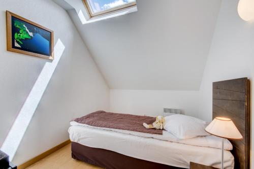 a bedroom with a bed with a stuffed animal on it at Vacancéole - Les Jardins de Balnéa in Loudenvielle