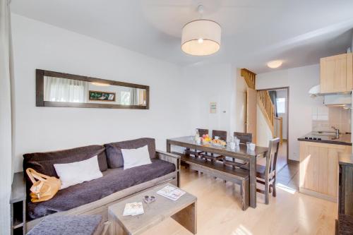 a living room with a couch and a table at Vacancéole - Les Jardins de Balnéa in Loudenvielle