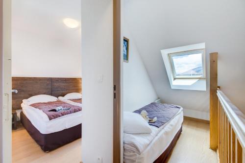 two beds in a small room with a window at Vacancéole - Les Jardins de Balnéa in Loudenvielle