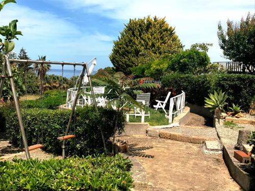 a garden with two white chairs and a swing at B&B Magna Grecia in Crotone
