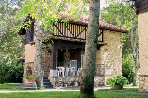 a stone house with a porch with white chairs at Casitas Del Huerto in La Alberca