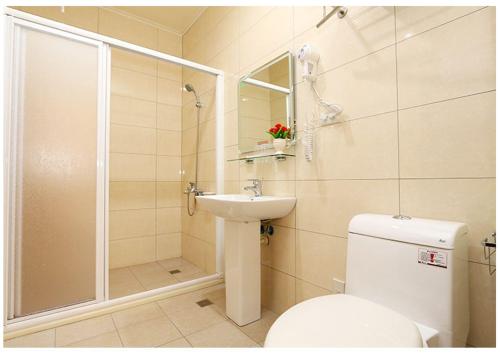 a bathroom with a toilet and a sink and a shower at Hong Lai Guest House in Jiaoxi