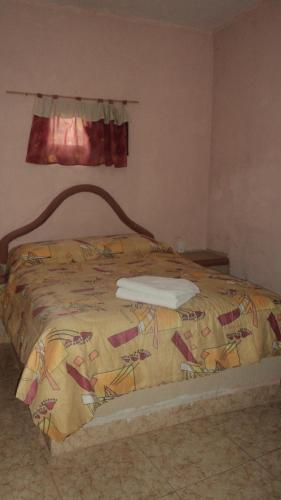 a bed in a bedroom with a blanket on it at Hotel Puerto Villamar in Tepoztlán