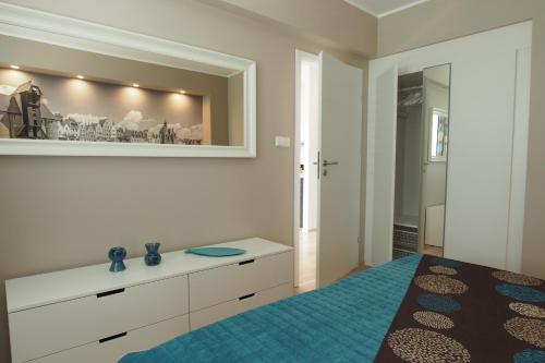 um quarto com uma cama e um espelho em Grand-Tourist Marine II em Gdańsk