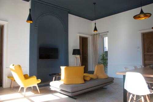 ヴィルフランシュ・ド・ルエルグにあるAppartement Du Fau De La Roqueのリビングルーム(黄色い椅子、テーブル付)