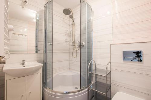 a bathroom with a shower and a toilet and a sink at Apartamenty Maja -Pokoje - Domy wakacyjne -Basen Podgrzewany -Jacuzzi in Łeba