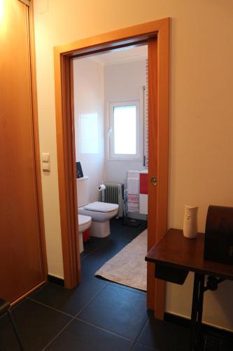 a small bathroom with a toilet and a window at Casa da Planicie in Évora