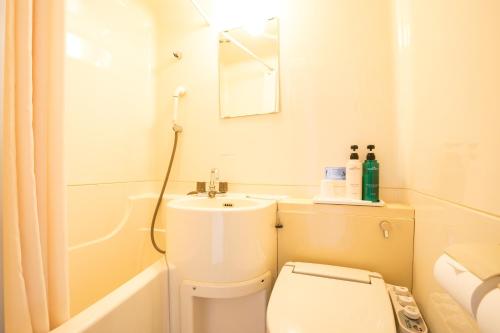 a small bathroom with a toilet and a sink at Hotel Los Inn Kochi in Kochi