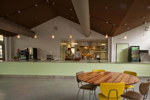 a kitchen with a wooden table and yellow chairs at WOW Amsterdam Hostel in Amsterdam