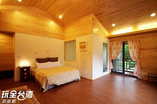MeishanにあるWalk Cloud Bed and Breakfastの木製の部屋にベッド1台が備わるベッドルーム1室があります。
