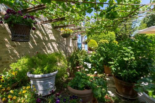 a garden with potted plants and flowers in buckets at Il Villino Hotel & SPA in Santarcangelo di Romagna