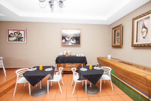 a dining room with two tables and white chairs at Vetho 1 Apartments OR Tambo Airport in Johannesburg