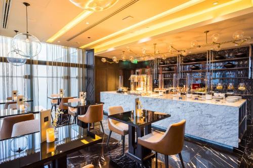 a restaurant with tables and chairs and a bar at SKYVIEW Hotel Bangkok - Sukhumvit in Bangkok