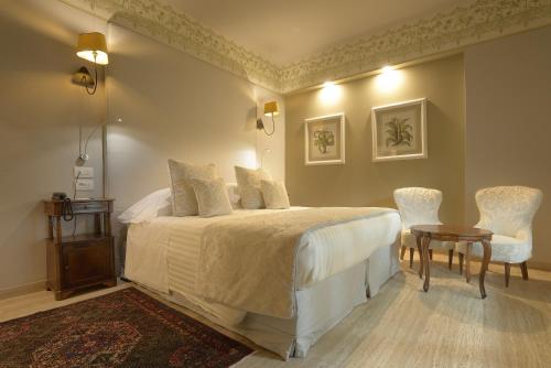 a bedroom with a bed and a table and chairs at Augustus Hotel & Resort in Forte dei Marmi