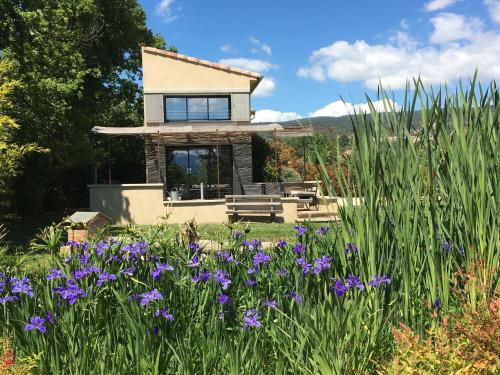 a house with a garden with purple flowers at L'ancien poulailler- The Old Hen House in Saint-Saturnin-dʼApt