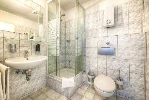 La salle de bains est pourvue de toilettes, d'un lavabo et d'une douche. dans l'établissement Hotel Senator, à Dortmund