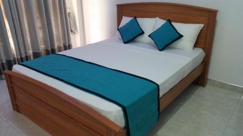 a bed with blue pillows in a room at Sunhill Lake Tourist Rest in Anuradhapura